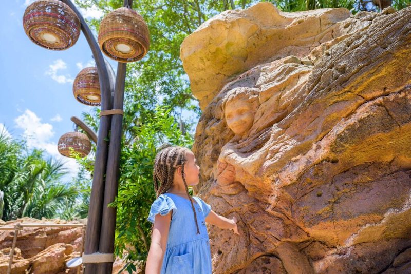 Menina e pedra esculpida na atração Moana: Journey of Water no Epcot da Disney Orlando